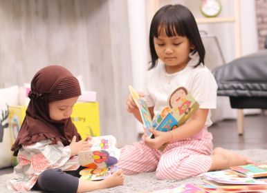 2 anak sedang membaca buku interaktif dari baby all baby